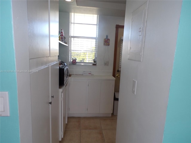 bathroom featuring electric panel and tile patterned flooring