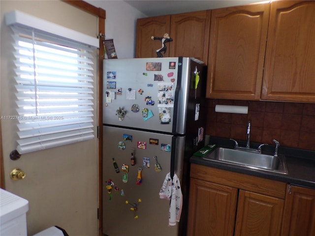 kitchen with stainless steel fridge, tasteful backsplash, and sink