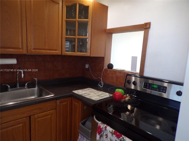 kitchen featuring black electric range, backsplash, and sink