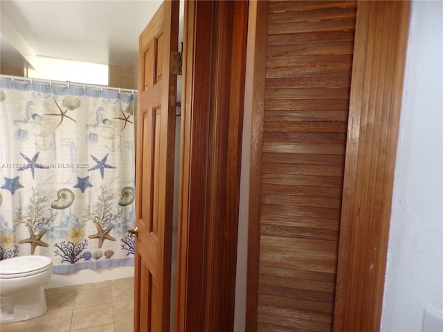 bathroom featuring tile patterned flooring, a shower with curtain, and toilet