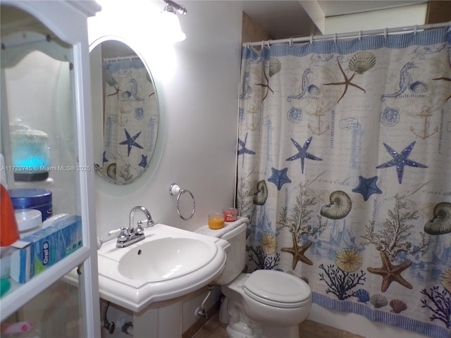 bathroom featuring curtained shower, toilet, and sink