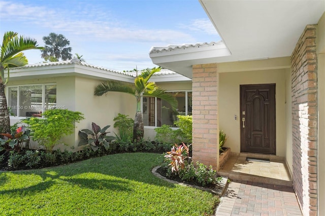 doorway to property featuring a lawn