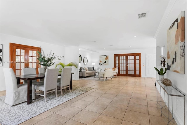 dining area with french doors, light tile patterned floors, and ornamental molding