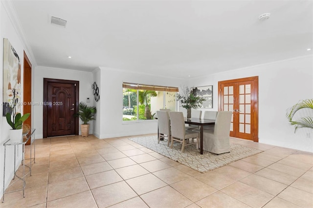 dining area with ornamental molding, light tile patterned floors, and french doors