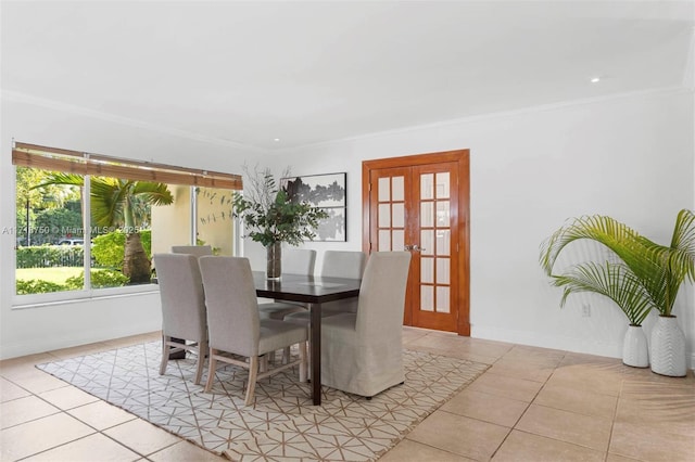 dining area with french doors, ornamental molding, and light tile patterned flooring