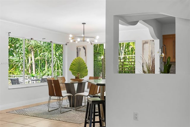 dining room featuring ornamental molding, light tile patterned floors, a healthy amount of sunlight, and an inviting chandelier