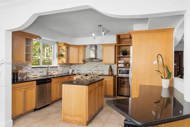 kitchen with appliances with stainless steel finishes, backsplash, wall chimney exhaust hood, a kitchen island, and light tile patterned flooring