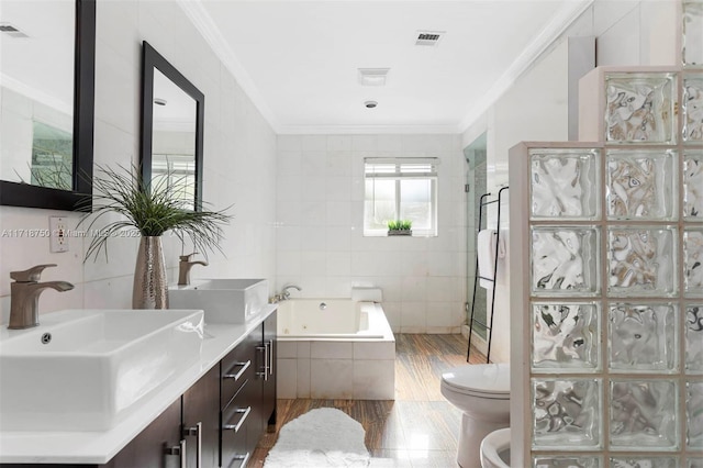 full bathroom featuring plus walk in shower, crown molding, toilet, vanity, and tile walls