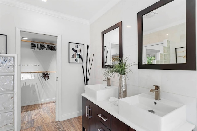 bathroom with hardwood / wood-style flooring, vanity, and ornamental molding