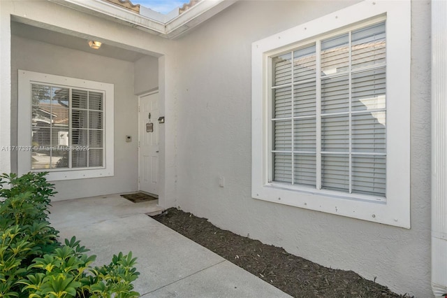 doorway to property featuring stucco siding