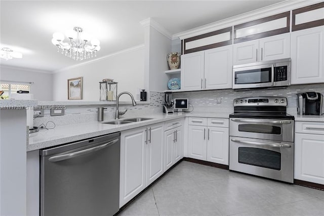 kitchen featuring a notable chandelier, crown molding, white cabinetry, appliances with stainless steel finishes, and sink