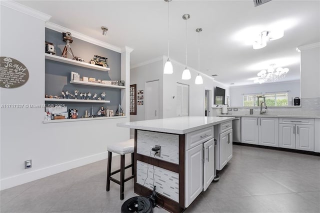 kitchen with sink, a kitchen island, ornamental molding, and hanging light fixtures