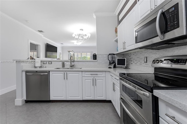 kitchen with a notable chandelier, crown molding, white cabinets, appliances with stainless steel finishes, and sink