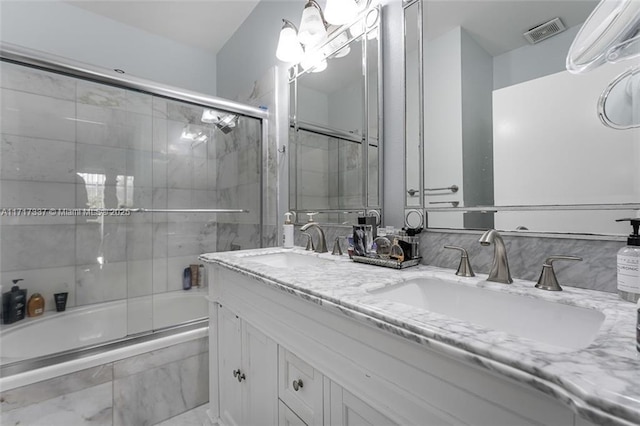 bathroom featuring vanity and bath / shower combo with glass door