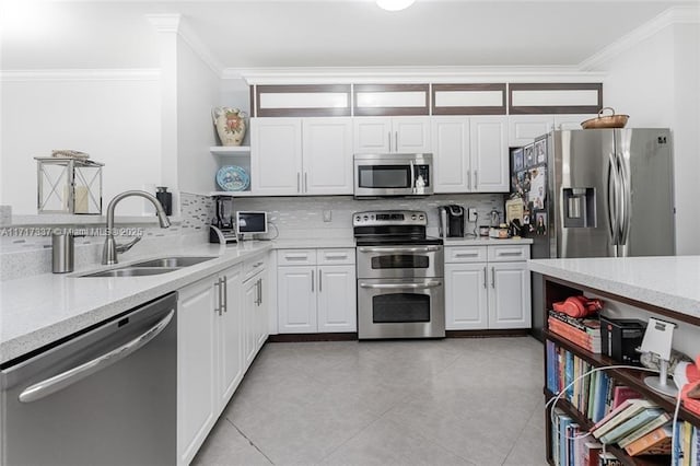 kitchen with tasteful backsplash, white cabinetry, appliances with stainless steel finishes, ornamental molding, and sink