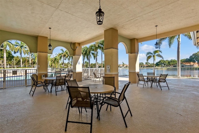 view of patio featuring a water view and fence