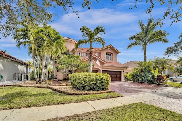 mediterranean / spanish-style home with a front yard and a garage