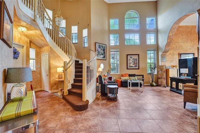 tiled foyer entrance with a towering ceiling