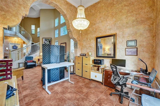 office area featuring a high ceiling, tile patterned floors, ornamental molding, and a chandelier