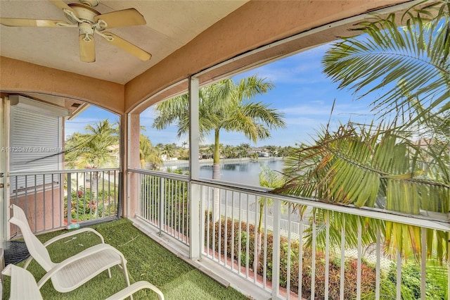 unfurnished sunroom featuring ceiling fan and a water view