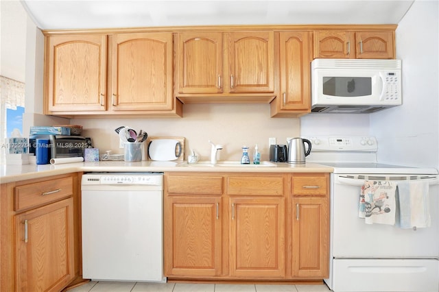 kitchen featuring sink, light tile patterned floors, white appliances, and light brown cabinets