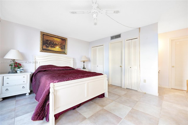 bedroom featuring ceiling fan and multiple closets