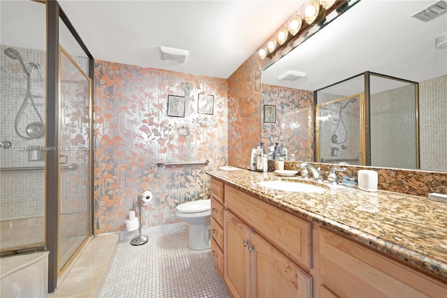 bathroom with toilet, vanity, tile patterned floors, and an enclosed shower