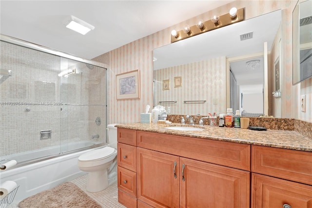 full bathroom featuring tile patterned flooring, vanity, bath / shower combo with glass door, and toilet