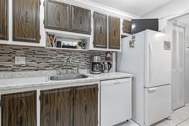 kitchen with decorative backsplash, dark brown cabinetry, white appliances, and sink