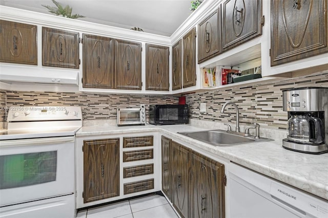 kitchen featuring decorative backsplash, dark brown cabinets, white appliances, sink, and light tile patterned floors