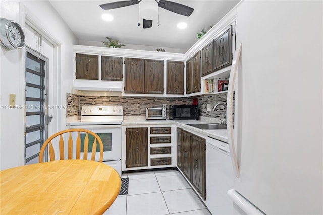 kitchen featuring sink, range hood, white appliances, decorative backsplash, and dark brown cabinets