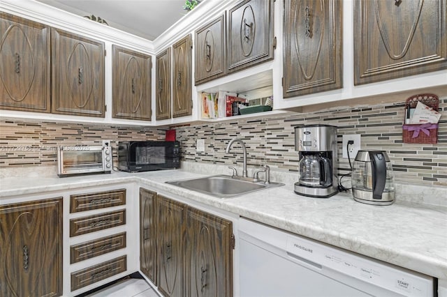 kitchen featuring white dishwasher, decorative backsplash, dark brown cabinetry, and sink