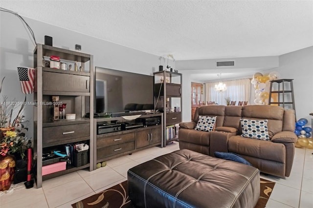 living room with a textured ceiling, an inviting chandelier, and light tile patterned flooring