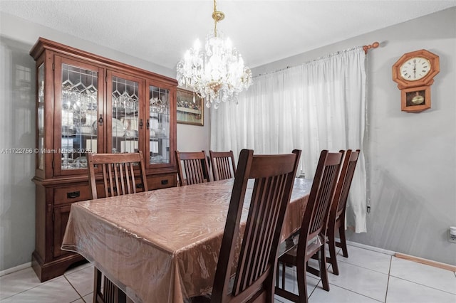 tiled dining area featuring a chandelier and a textured ceiling