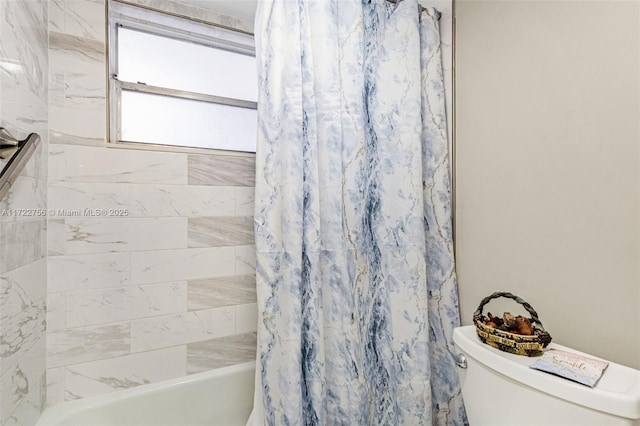 bathroom featuring shower / bath combo and toilet