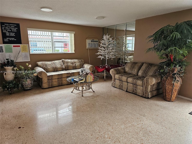 living room featuring an AC wall unit and a textured ceiling