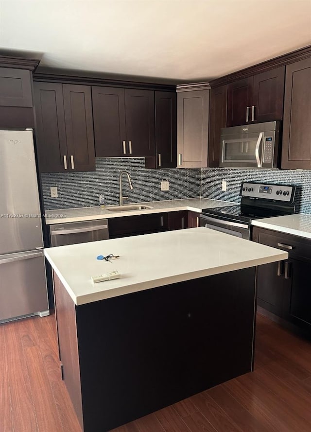 kitchen featuring dark brown cabinets, stainless steel appliances, sink, wood-type flooring, and a kitchen island