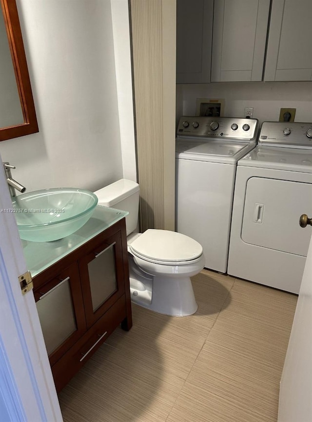 bathroom with toilet, vanity, and independent washer and dryer