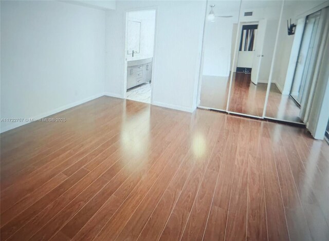 unfurnished bedroom with light hardwood / wood-style flooring, connected bathroom, and a closet