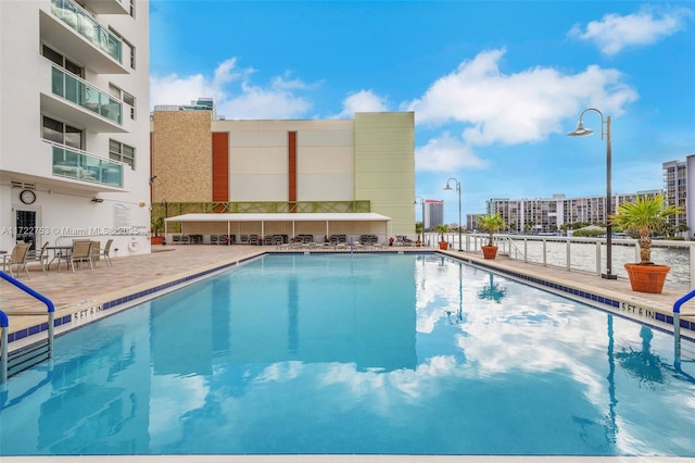 pool with a patio area and a view of city