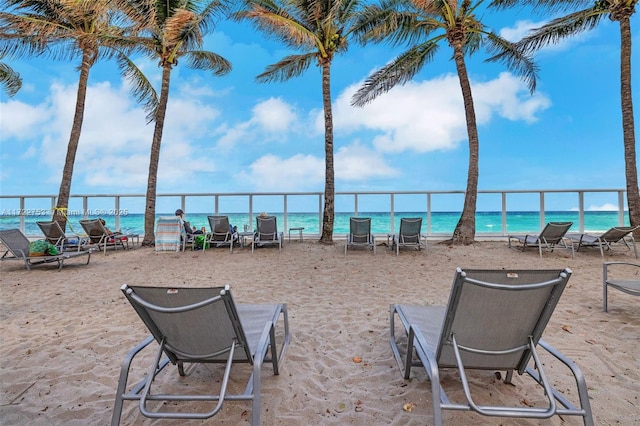 view of patio featuring a water view and a beach view