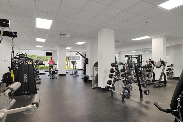 gym with a paneled ceiling and visible vents