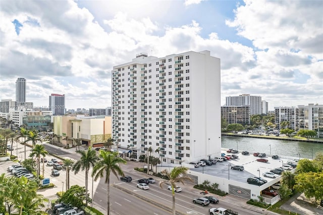 exterior space with uncovered parking, a view of city, and a water view