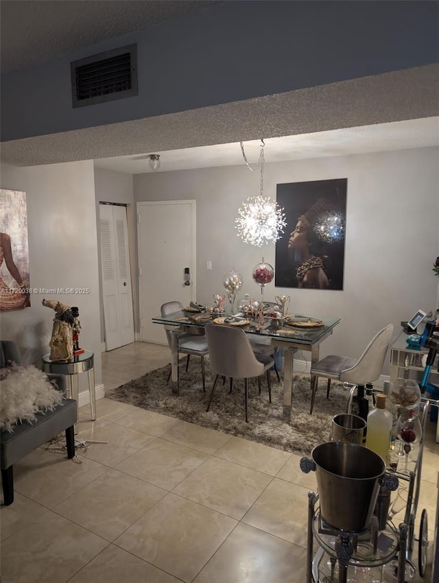 tiled dining room featuring a notable chandelier