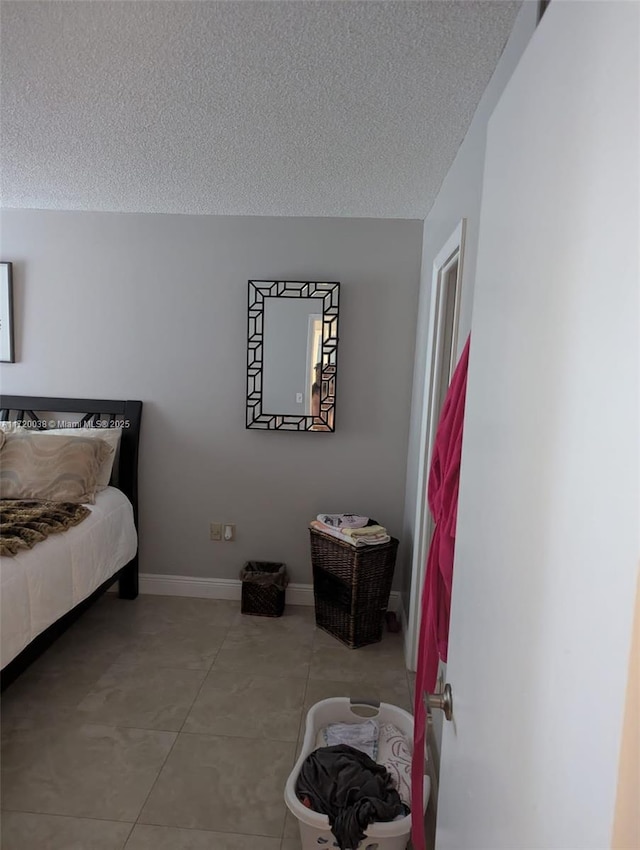 bedroom with light tile patterned floors and a textured ceiling