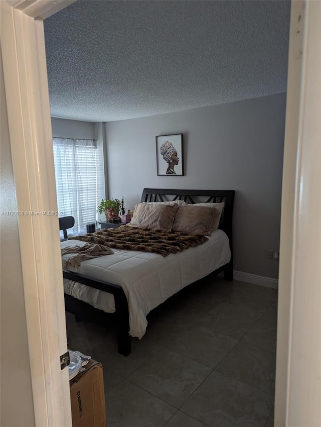 tiled bedroom featuring a textured ceiling