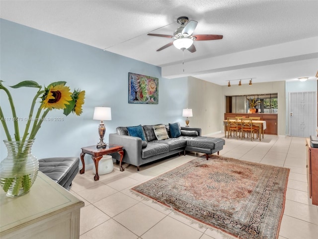 tiled living room with ceiling fan and a textured ceiling