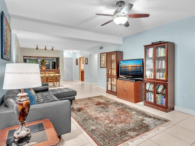 tiled living room with a textured ceiling and ceiling fan