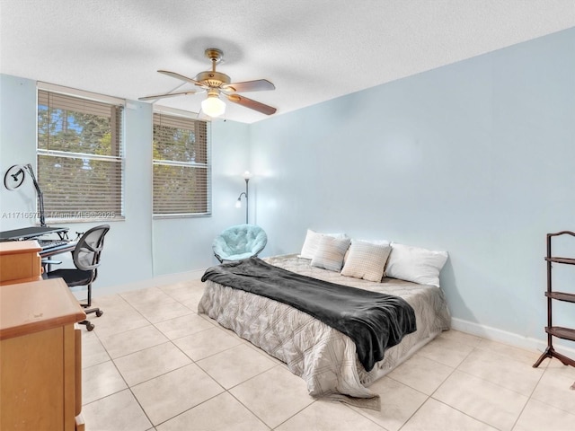 tiled bedroom featuring ceiling fan and a textured ceiling