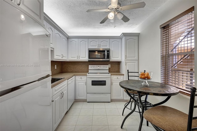 kitchen featuring white cabinets, white appliances, light tile patterned floors, and tasteful backsplash